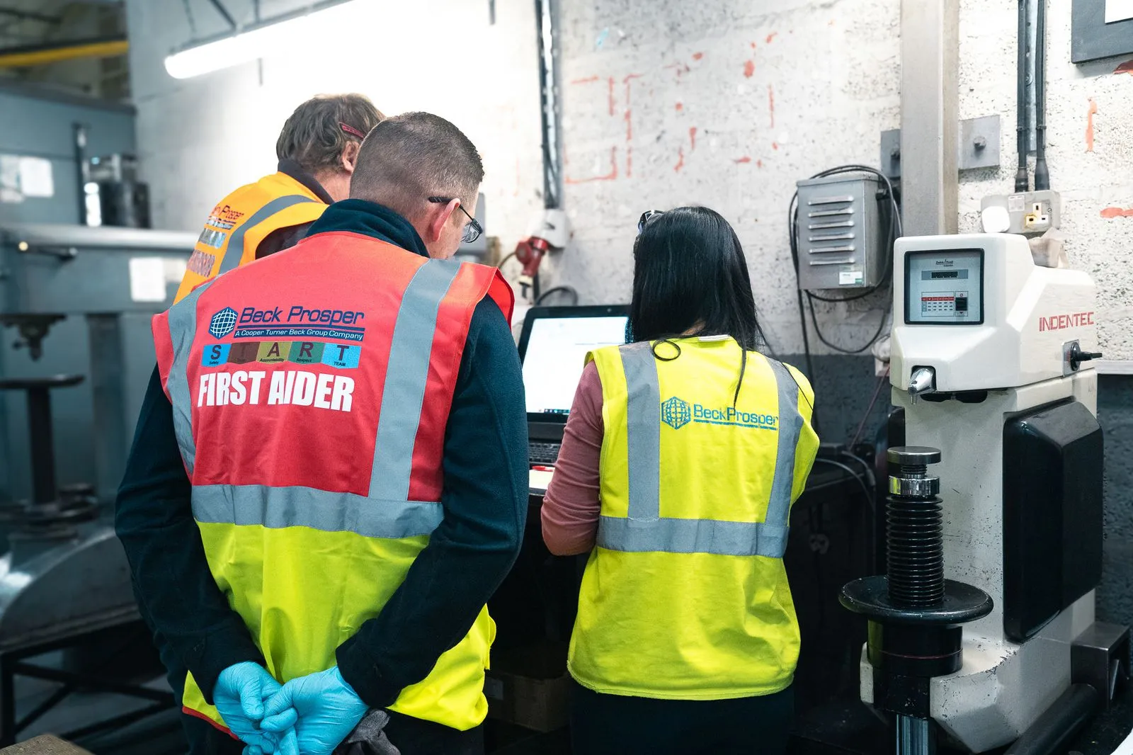 Picture of three people looking at a machine